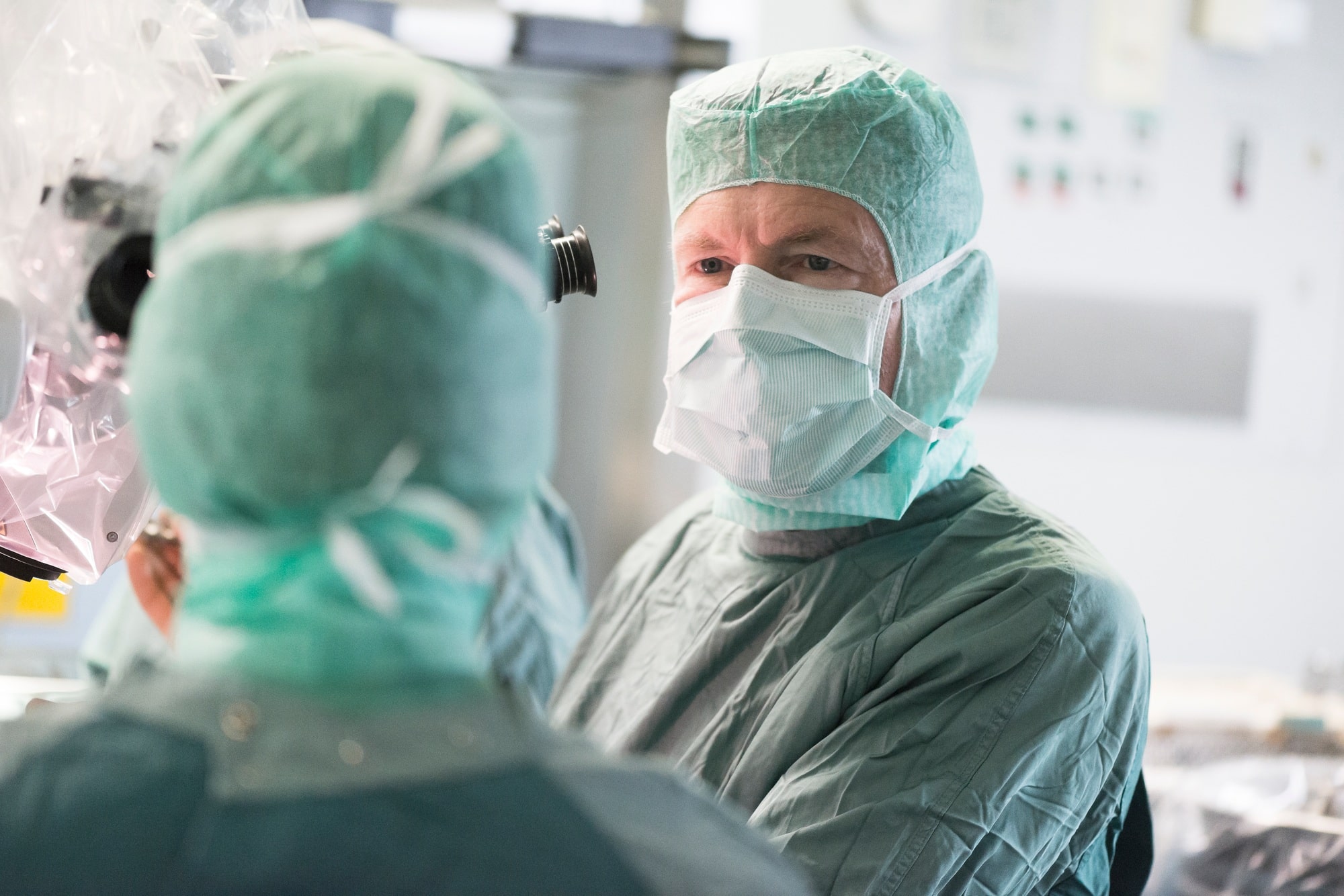 Neurosurgeon consulting colleague during an operation