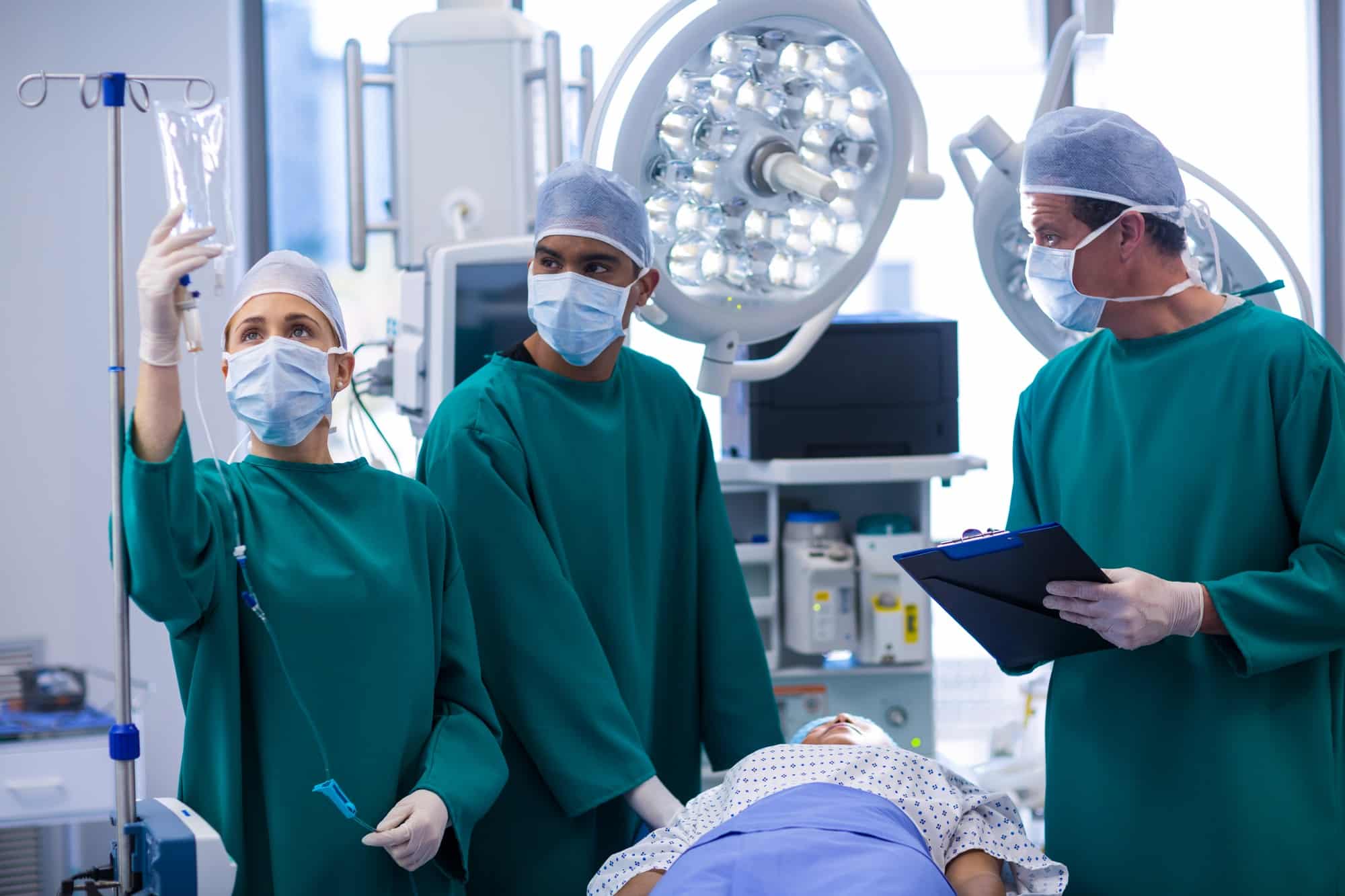 Surgeons adjusting iv drip in operation theater