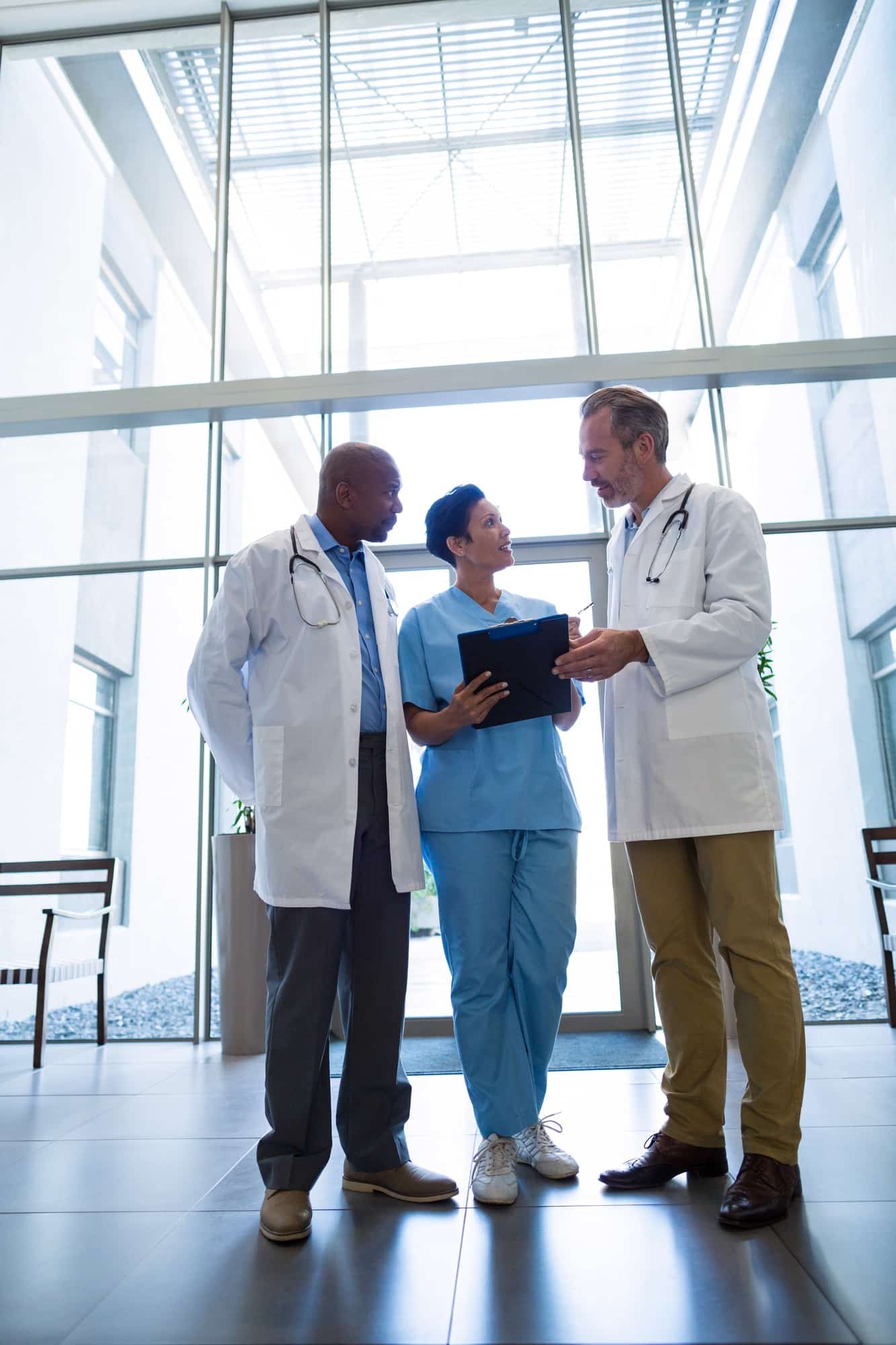 Surgeons and nurse discussing reports