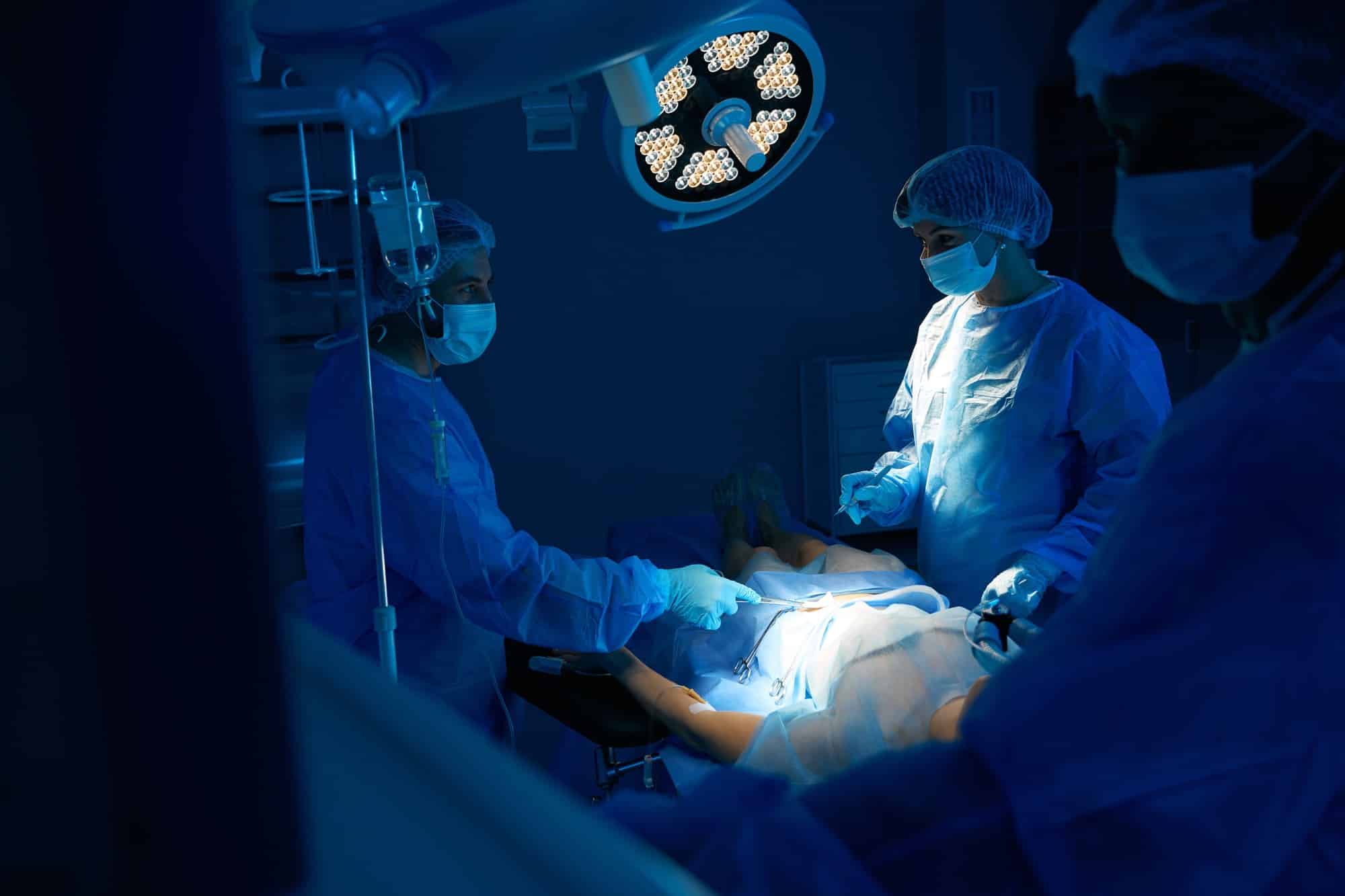 Team of surgeons and nurse performing operation